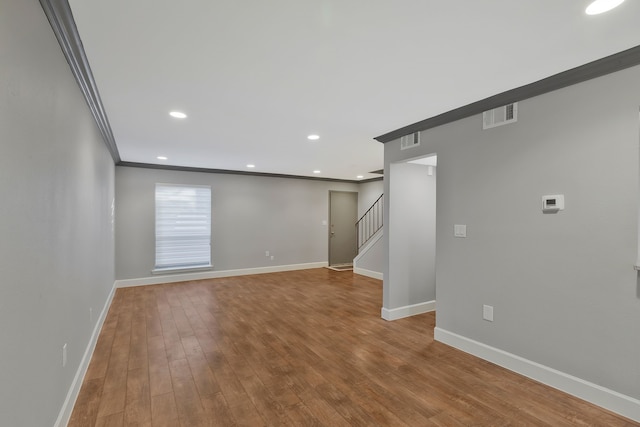 empty room with wood-type flooring and ornamental molding