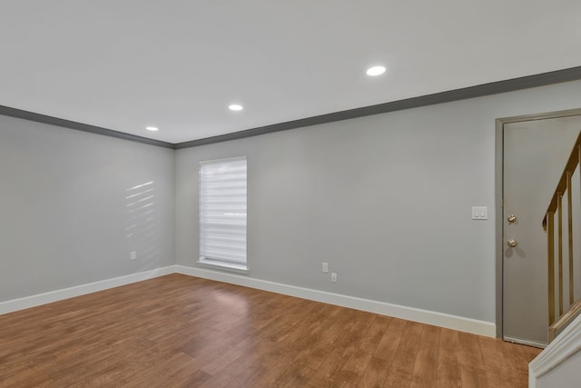 empty room featuring crown molding and hardwood / wood-style floors