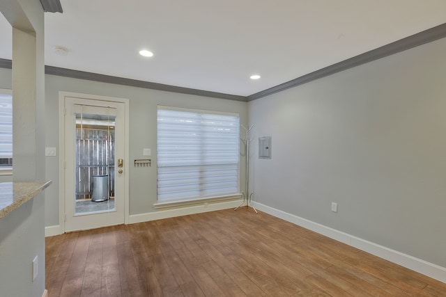 doorway with hardwood / wood-style floors, crown molding, and electric panel