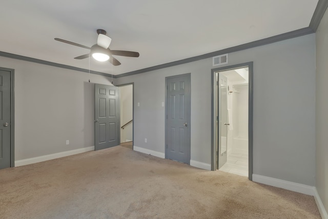 unfurnished bedroom featuring ensuite bath, ceiling fan, crown molding, and light carpet