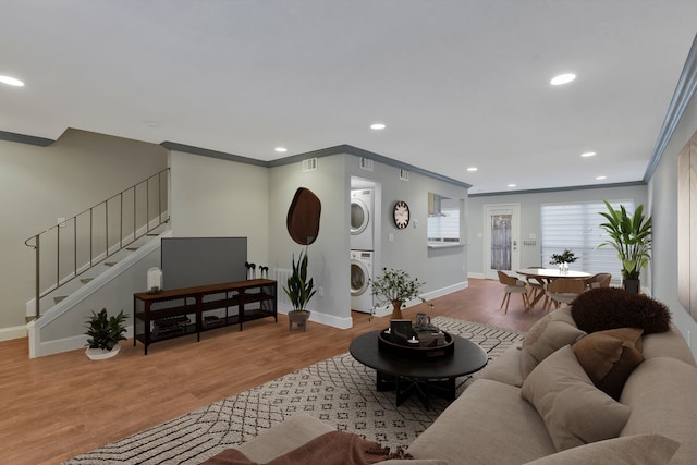 7861 Meadow Park Dr Unit A, Dallas, TX 75230 - living area featuring baseboards, stacked washing maching and dryer, ornamental molding, wood finished floors, and stairs