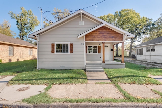 bungalow featuring covered porch and a front yard