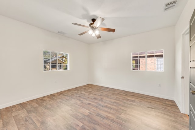 unfurnished room with a wealth of natural light, ceiling fan, and light hardwood / wood-style floors