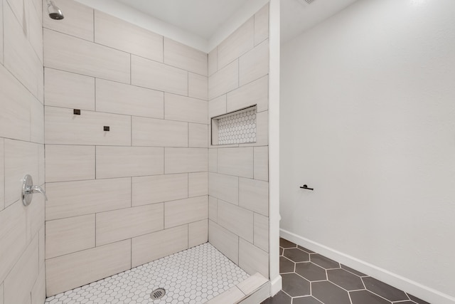 bathroom with tile patterned flooring and a tile shower