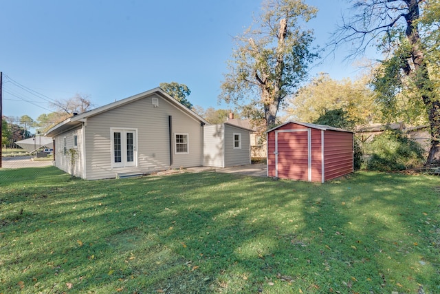 rear view of house featuring a storage unit and a yard