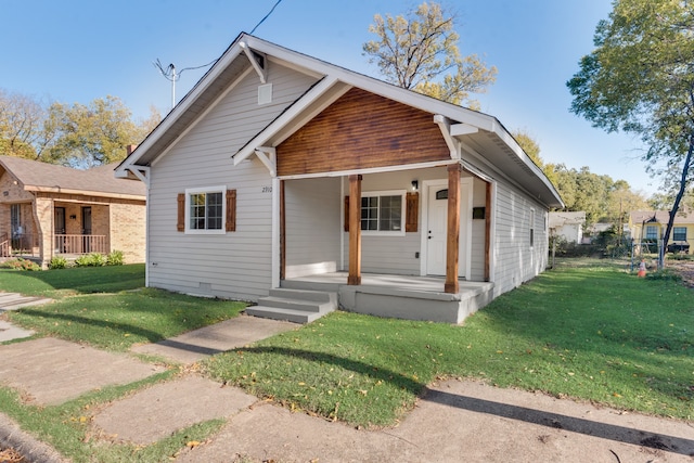 bungalow-style home with a front lawn and covered porch