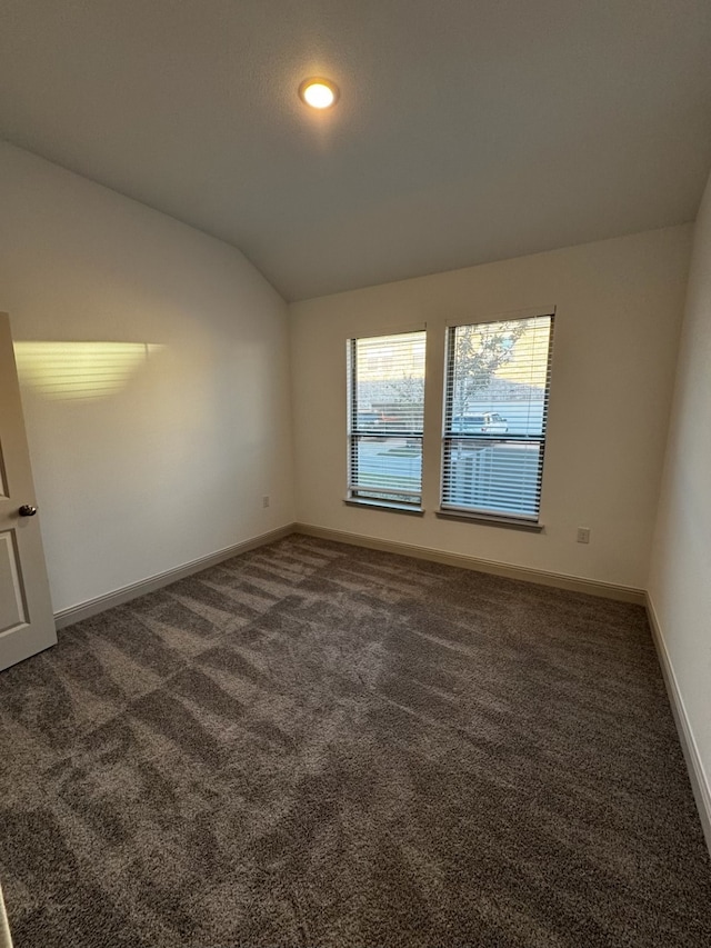 carpeted spare room with lofted ceiling