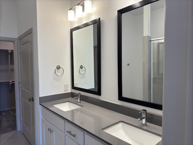 bathroom featuring tile patterned flooring, vanity, and a shower with door