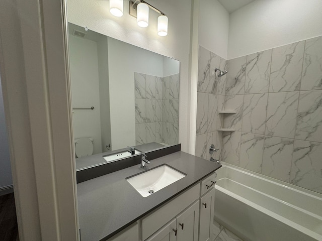 full bathroom with vanity, tiled shower / bath combo, and toilet