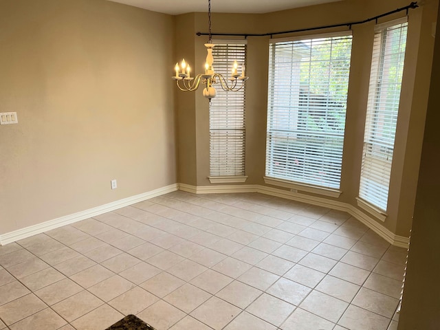 tiled empty room featuring an inviting chandelier