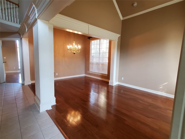 spare room with ornate columns, high vaulted ceiling, crown molding, a chandelier, and wood-type flooring