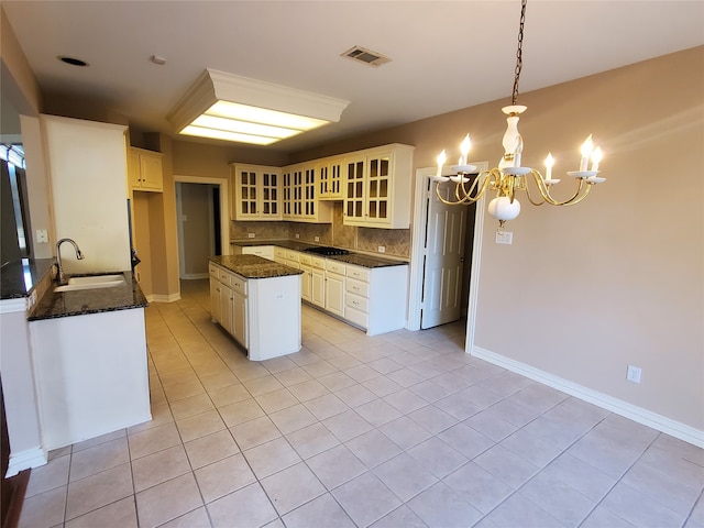 kitchen with pendant lighting, sink, decorative backsplash, light tile patterned flooring, and a chandelier