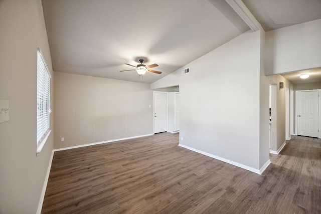 empty room with ceiling fan, dark hardwood / wood-style flooring, and vaulted ceiling