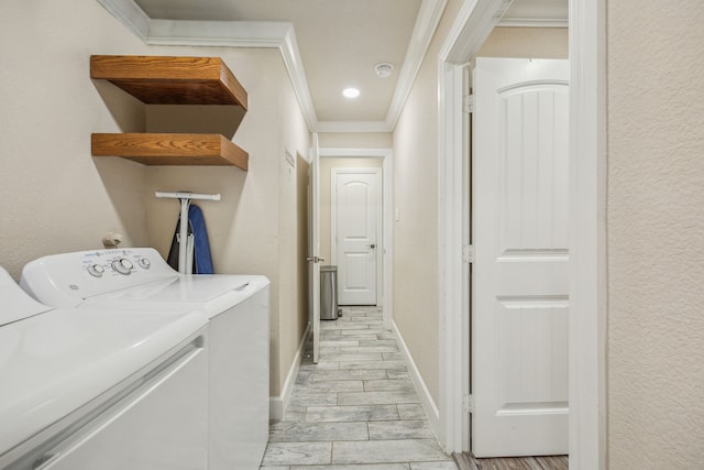 clothes washing area with light wood-type flooring, separate washer and dryer, and crown molding