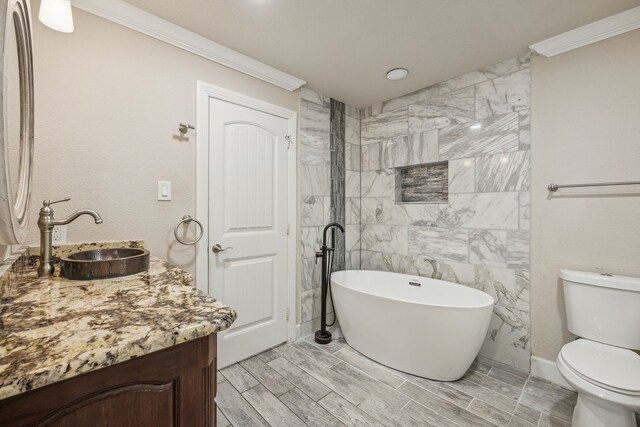 bathroom featuring toilet, a washtub, vanity, and ornamental molding