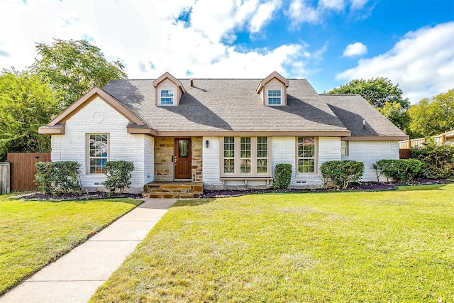 cape cod home featuring a front yard