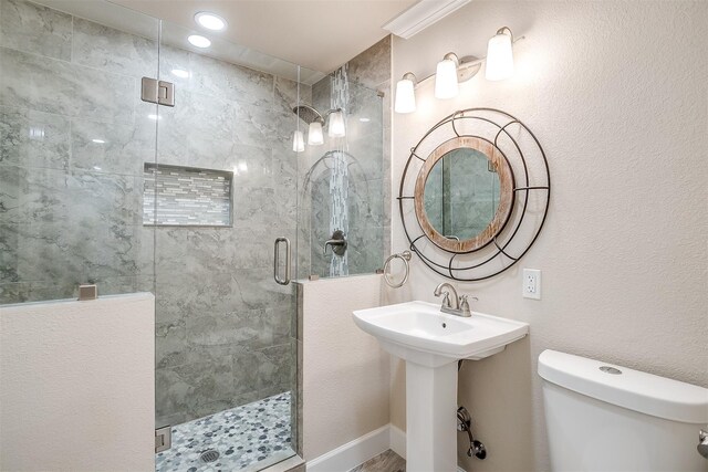 bathroom featuring toilet and a shower with shower door