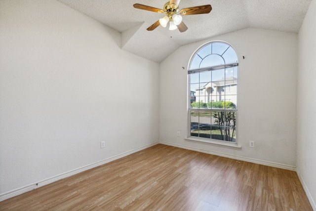 1306 Woodmont Dr, Allen, TX 75002 - spare room with a textured ceiling, light wood finished floors, a ceiling fan, lofted ceiling, and baseboards