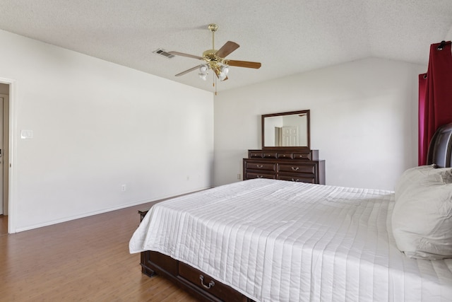 1306 Woodmont Dr, Allen, TX 75002 - bedroom featuring lofted ceiling, a textured ceiling, wood finished floors, a ceiling fan, and baseboards