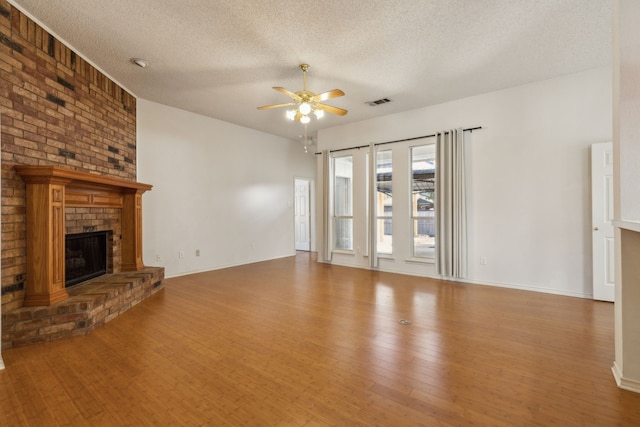 1306 Woodmont Dr, Allen, TX 75002 - unfurnished living room featuring a fireplace, ceiling fan, a textured ceiling, wood finished floors, and baseboards