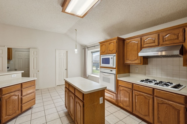 1306 Woodmont Dr, Allen, TX 75002 - kitchen with white appliances, under cabinet range hood, lofted ceiling, light countertops, and brown cabinets