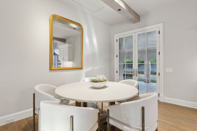 dining area with wood-type flooring and beam ceiling