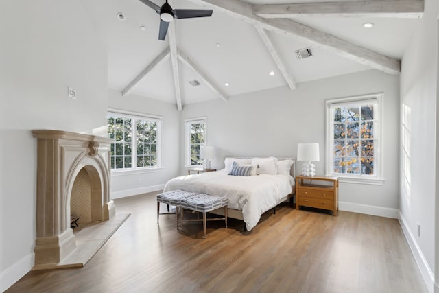 bedroom with ceiling fan, lofted ceiling with beams, and light wood-type flooring