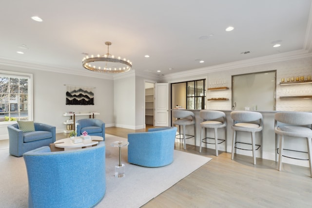 living room with light hardwood / wood-style floors, an inviting chandelier, and crown molding