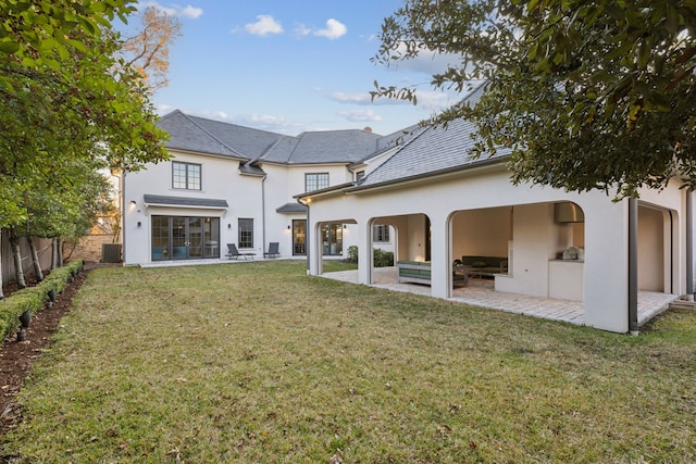 back of property featuring a yard, central AC, and a patio area