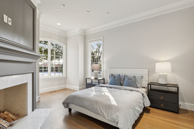 bedroom with light wood-type flooring and crown molding