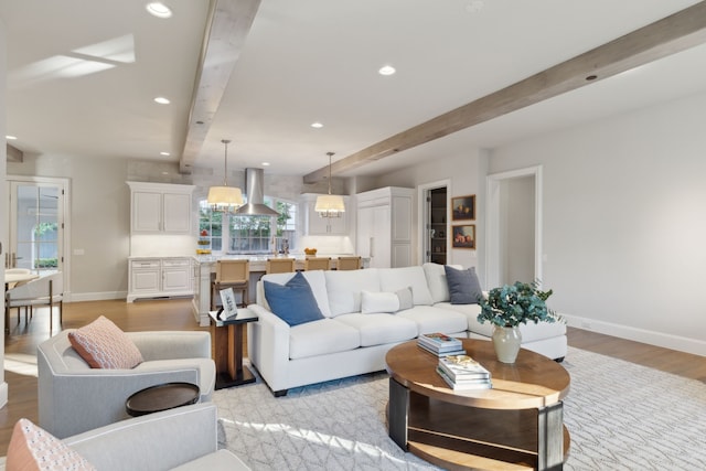 living room with beam ceiling and light wood-type flooring