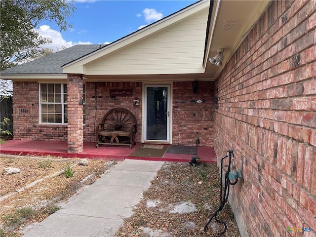 view of exterior entry with a patio