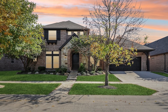 view of front facade with a yard and a garage