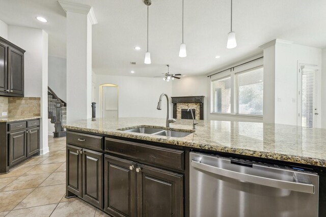 kitchen with dishwasher, dark brown cabinetry, light stone countertops, and sink