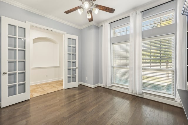 spare room featuring french doors, crown molding, a wealth of natural light, and dark wood-type flooring