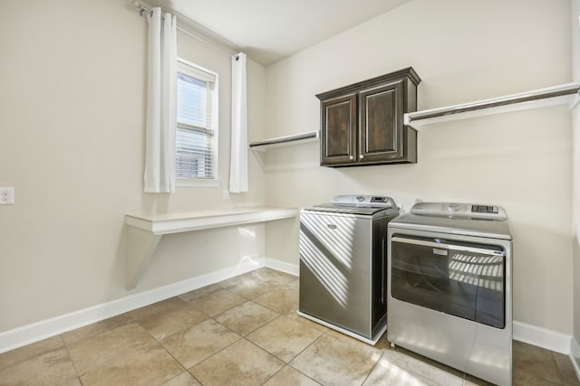 washroom with separate washer and dryer, light tile patterned floors, and cabinets