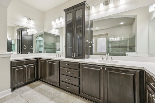 bathroom with tile patterned floors, vanity, and tiled shower