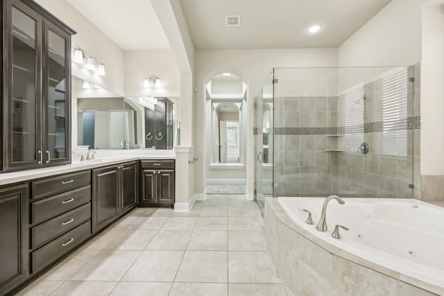 bathroom featuring vanity, tile patterned flooring, and plus walk in shower