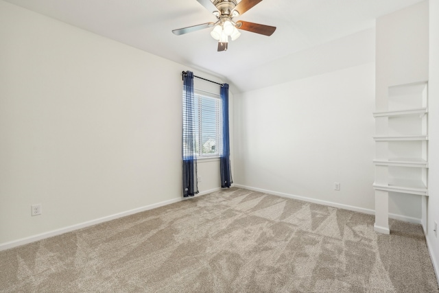 empty room featuring ceiling fan, light colored carpet, and vaulted ceiling