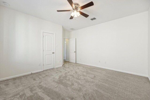 carpeted spare room with ceiling fan