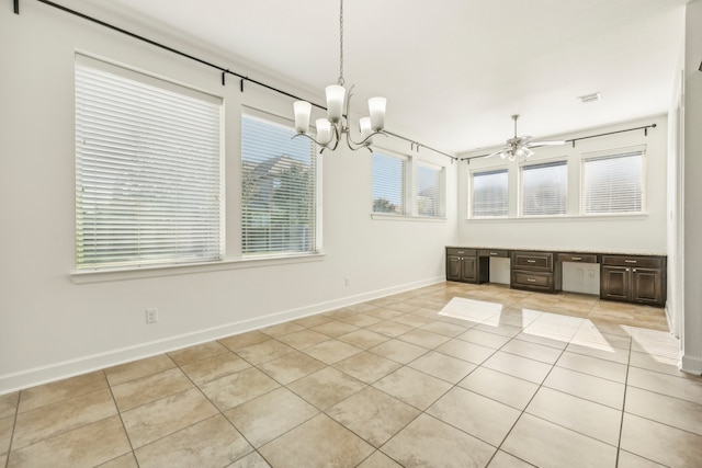 unfurnished dining area with light tile patterned flooring and ceiling fan with notable chandelier