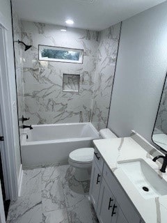 full bathroom featuring toilet, vanity, and tiled shower / bath