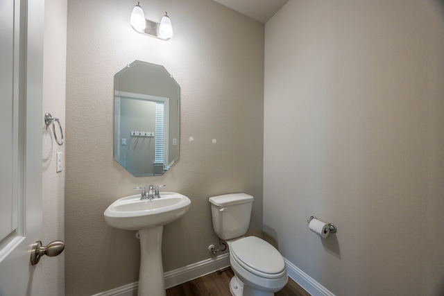 bathroom featuring wood-type flooring, toilet, and sink