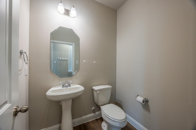 321 Baker Dr, Plano, TX 75074 - half bathroom with toilet, wood finished floors, a sink, and baseboards