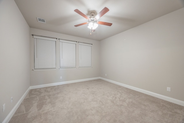 carpeted spare room featuring ceiling fan