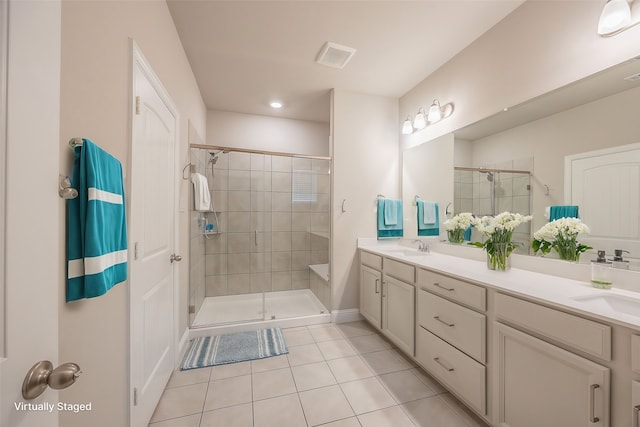 bathroom with tile patterned floors, vanity, and walk in shower