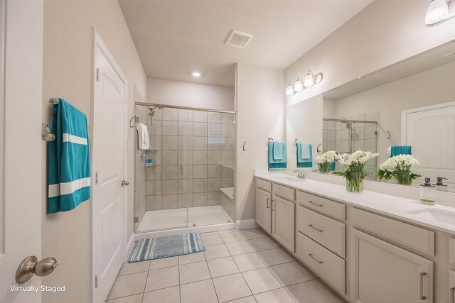 bathroom with tile patterned floors, vanity, and walk in shower