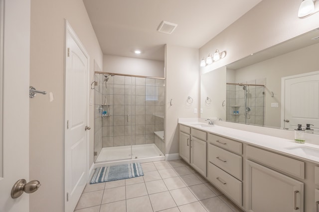 bathroom featuring tile patterned flooring, vanity, and a shower with door