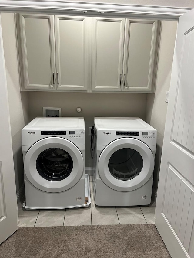 321 Baker Dr, Plano, TX 75074 - laundry area featuring independent washer and dryer, cabinet space, and light tile patterned flooring