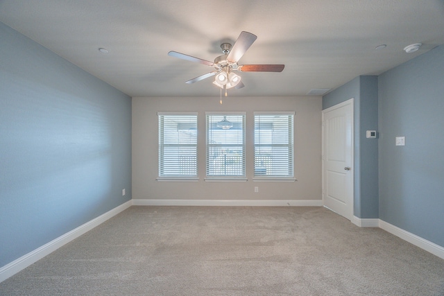 spare room featuring ceiling fan and light colored carpet